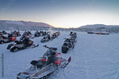 Group of snowmobiles in Finnish Lapland. Scenic snowy landscape in winter wonderland