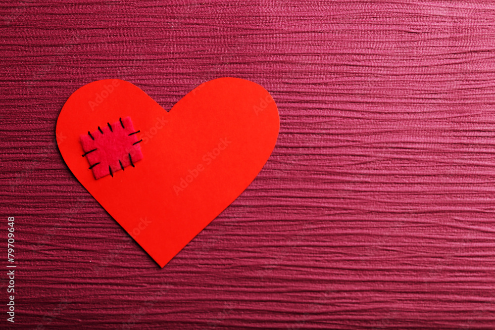 Patch on broken heart on colour background Patch on broken heart on colour background