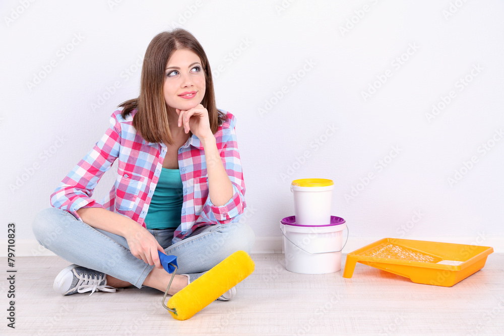 Beautiful girl sitting on floor with equipment for painting Beautiful girl sitting on floor with equipment for painting