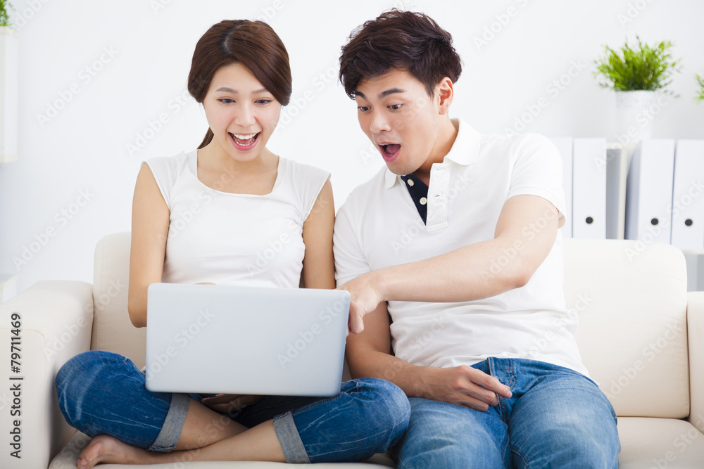 surprised Couple on sofa with laptop computer surprised Couple on sofa with laptop computer