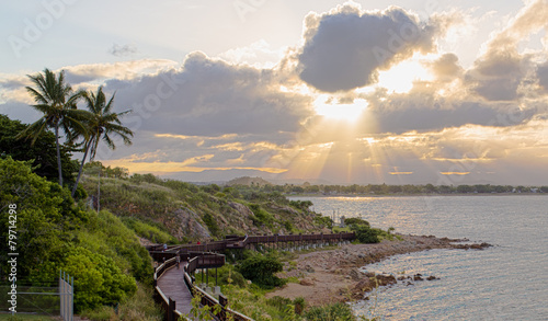 Tropical sunset with a view of wooden bridge over the rocky coas