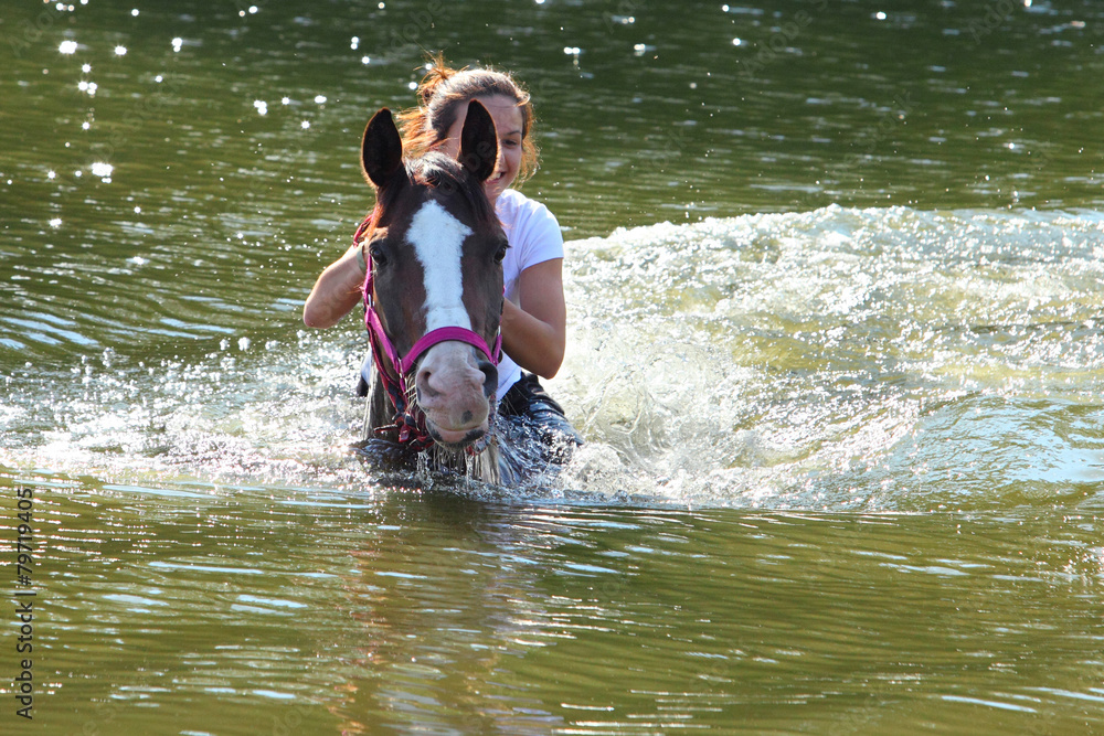 Fototapeta premium Girl swiming with her horse in river