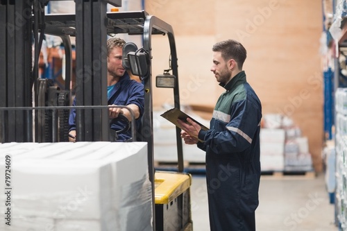 Warehouse worker talking with forklift driver © WavebreakMediaMicro