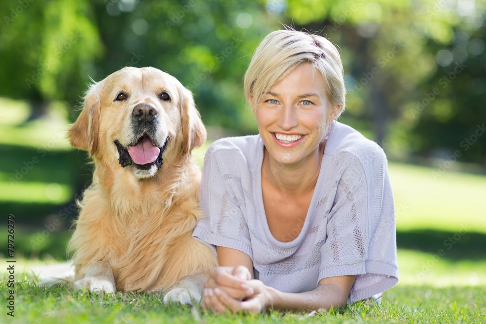 Happy blonde lying with her dog in the park Happy blonde lying with her dog in the park
