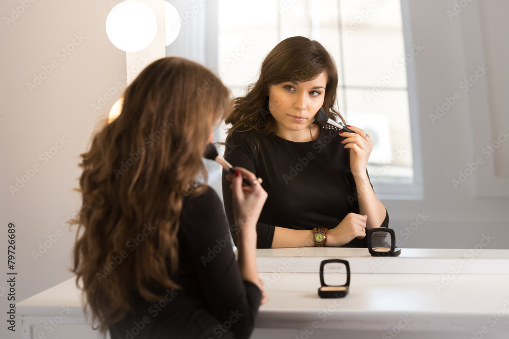 beautiful brunette woman sitting at mirror and doing makeup beautiful brunette woman sitting at mirror and doing makeup