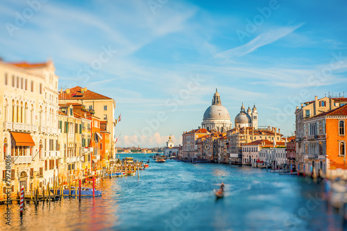 Bright sunny view of The Grand Canal with gondola the Santa Maria della Salute church, Venice, Italy
