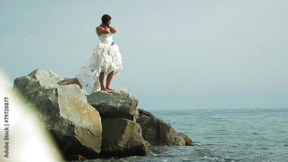 Young Woman In White Dress Standing On Rock By Sea Young Woman In White Dress Standing On Rock By Sea
