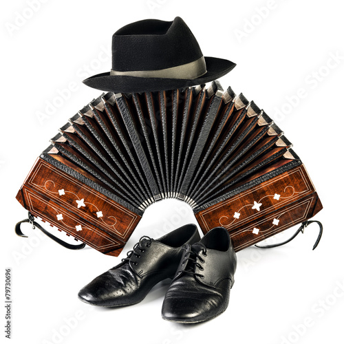 Bandoneon, tango shoes and a black hat isolated on white