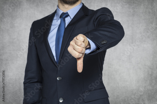 Businessman pointing thumbs down
