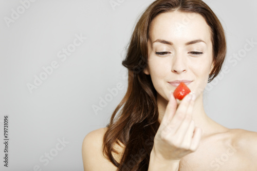 Woman holding up a strawberry