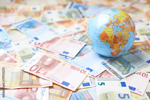 Earth globe over the pile of money