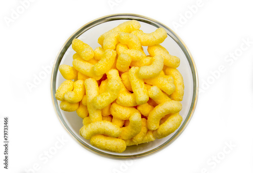 Corn snacks on bowl on white background seen from above