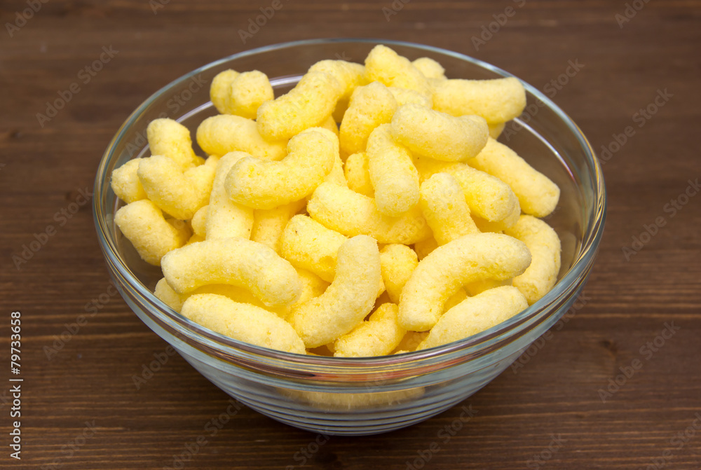 Corn snacks on bowl on wooden table