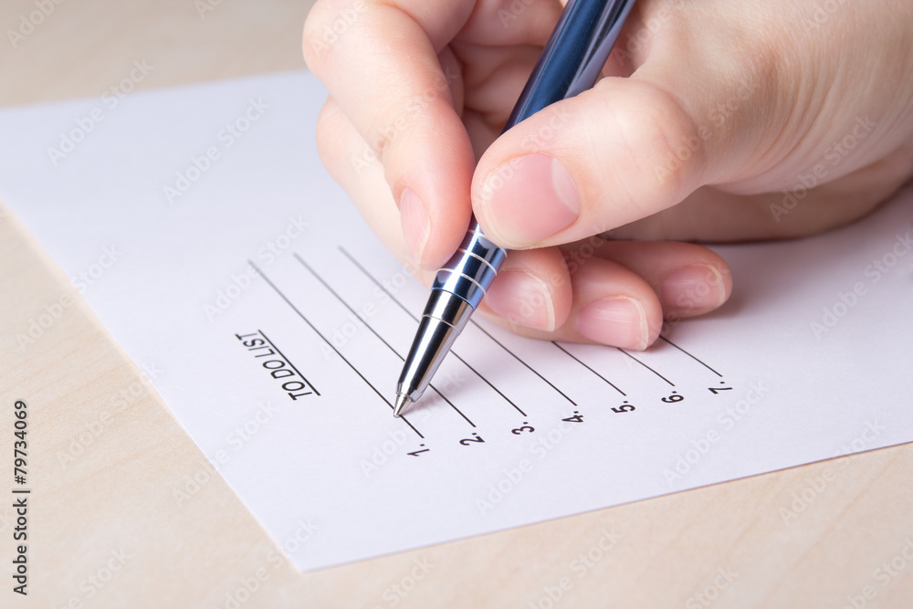 female hand filling to do list with pen female hand filling to do list with pen