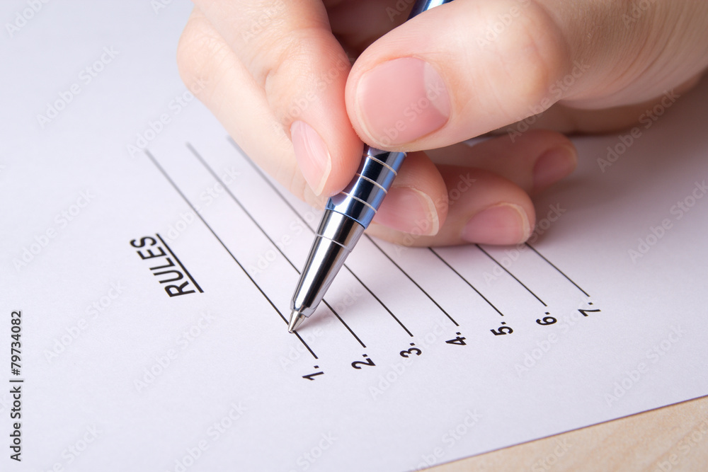 female hand filling rules list with pen female hand filling rules list with pen