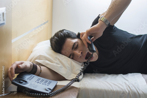 Sleepy Man on Bed Yawning While Talking at the Telephone