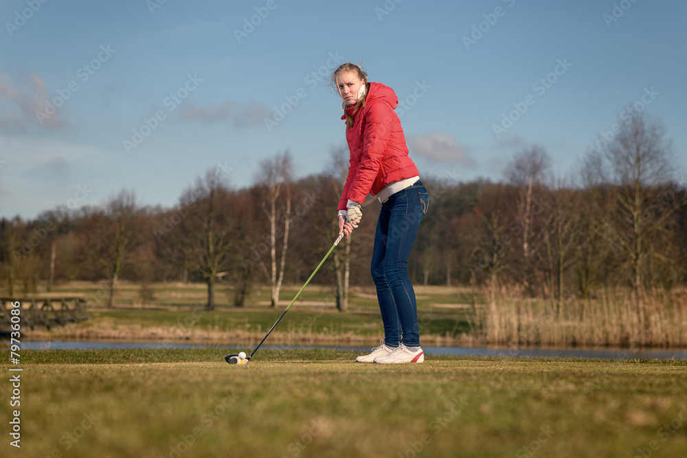 Frau beim Abschlag auf einem Golfplatz - obrazy, fototapety, plakaty 