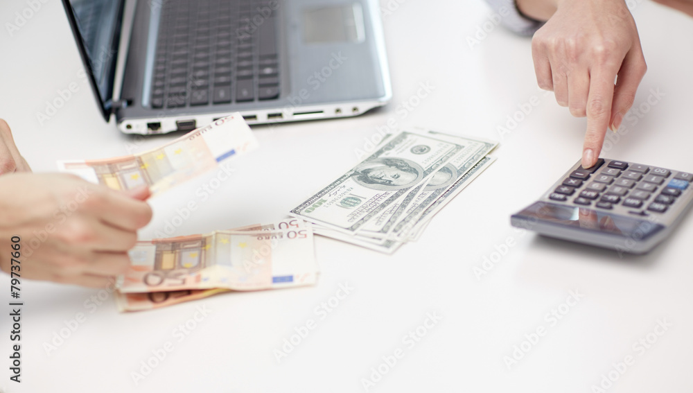close up of hands counting money with calculator close up of hands counting money with calculator