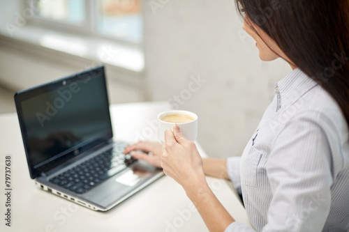 close up of woman with laptop drinking coffee