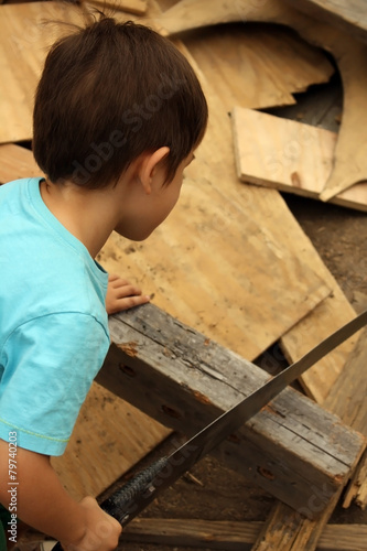 Child sawing wood at adventure playground