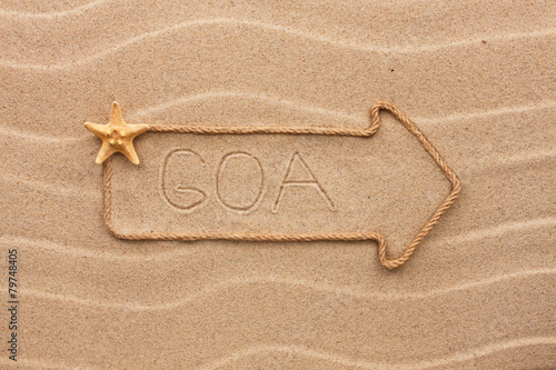 Arrow made of rope and sea shells with the word Goa on the sand