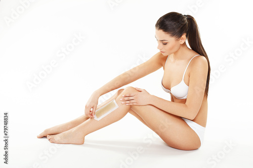 Young woman waxing legs