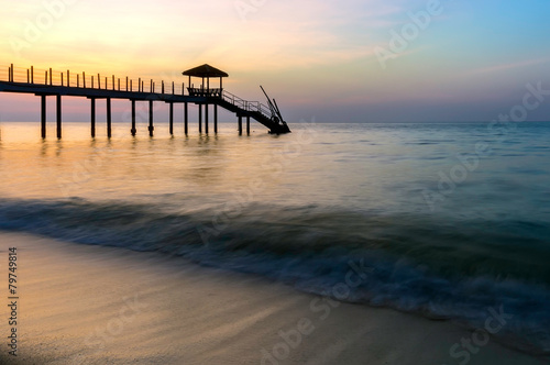 Colorful sunset at tropical beach with jetty © Mohamad Zaki
