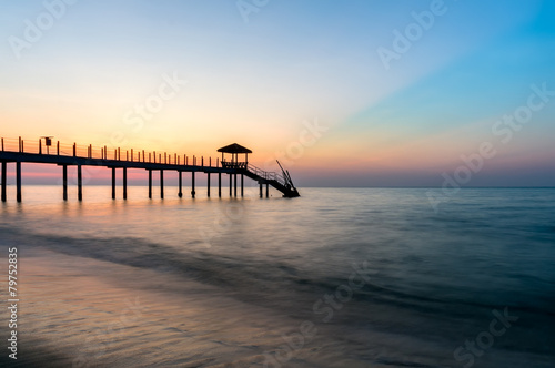 Colorful sunset at tropical beach with jetty © Mohamad Zaki