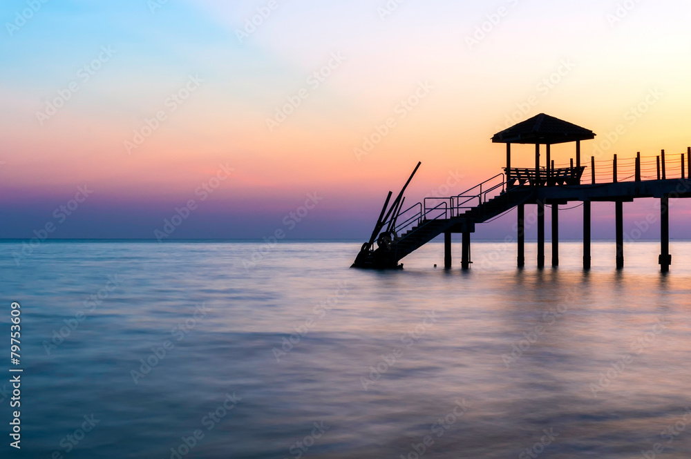 Colorful sunset at tropical beach with jetty