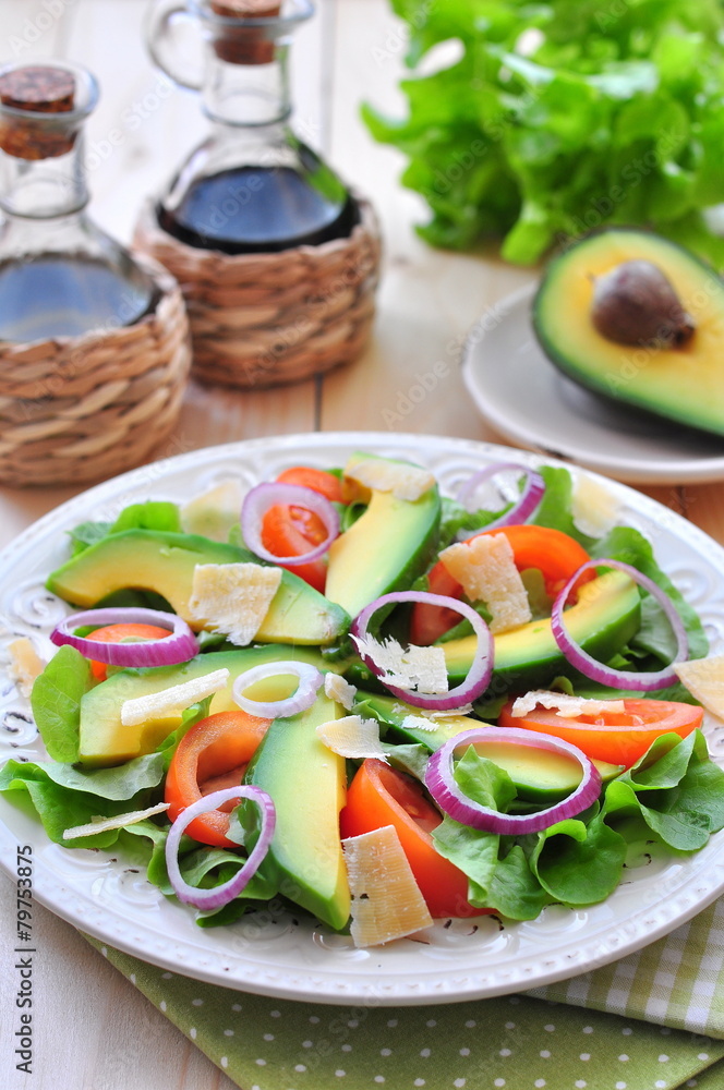 Fresh salad with tomatoes, lettuce, avocado and parmesan cheese Fresh salad with tomatoes, lettuce, avocado and parmesan cheese