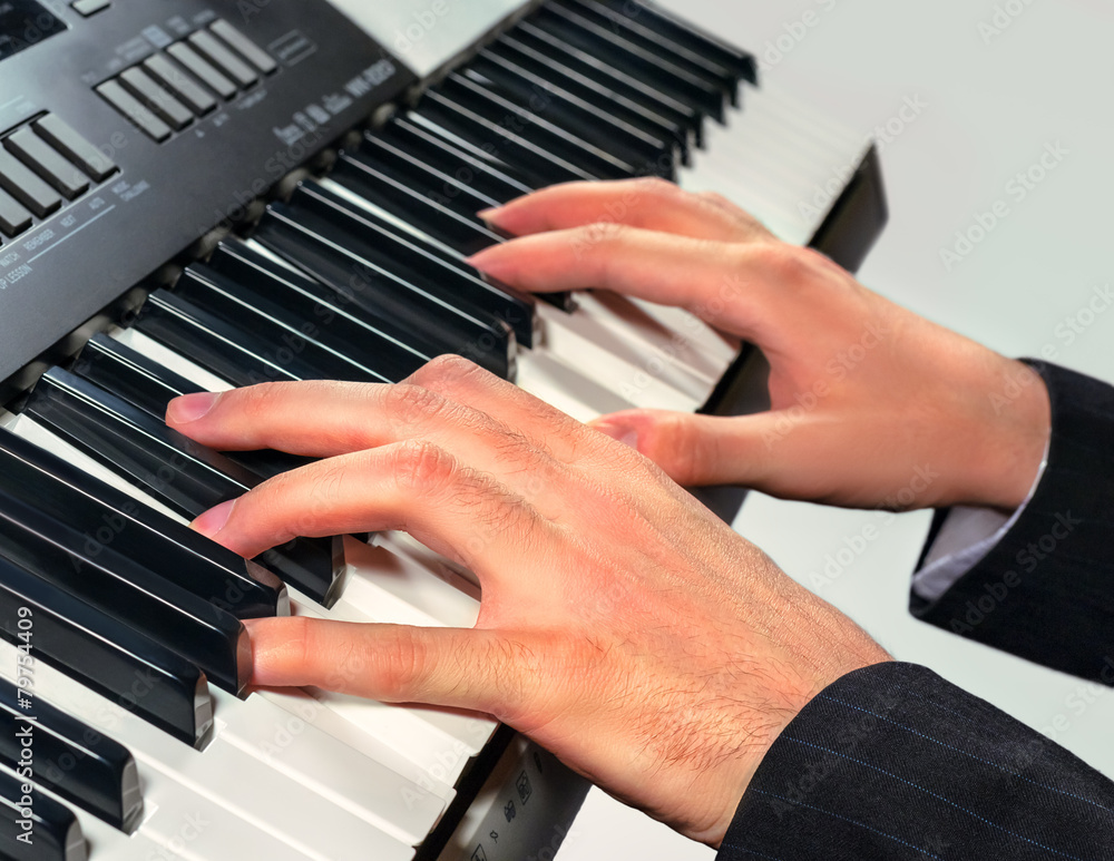 Obraz premium Hands of musician playing on a synthesizer, isolated on a white