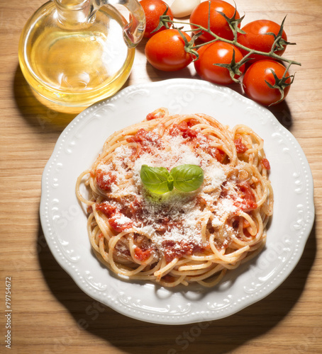 dish with spaghetti and tomato sauce on the wooden table