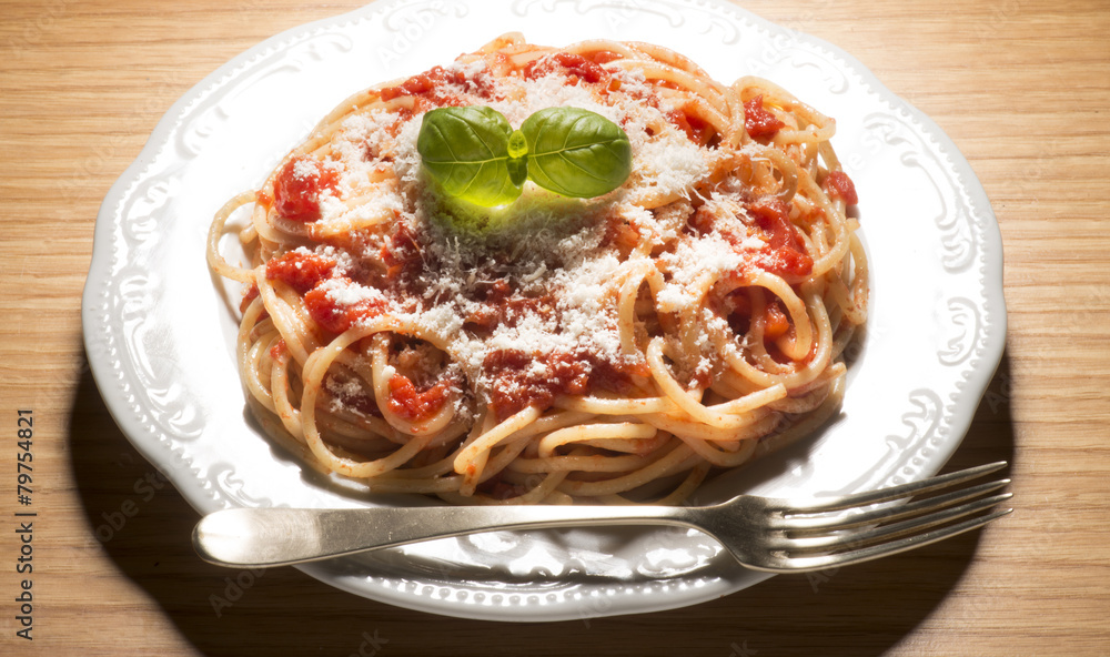dish with spaghetti and tomato sauce on the wooden table dish with spaghetti and tomato sauce on the wooden table