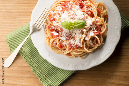 dish with spaghetti and tomato sauce on the wooden table