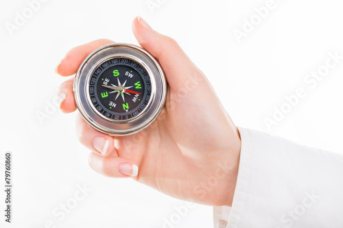 Woman holding small compass. Isolated in a white background.