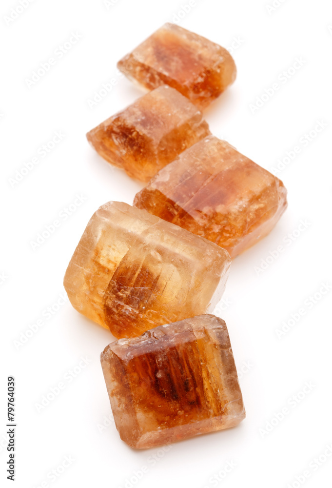 Brown caramelized lump cane sugar cube isolated on white backgro Brown caramelized lump cane sugar cube isolated on white backgro