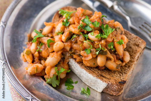 Stewed white beans in tomato sauce on toasted bread