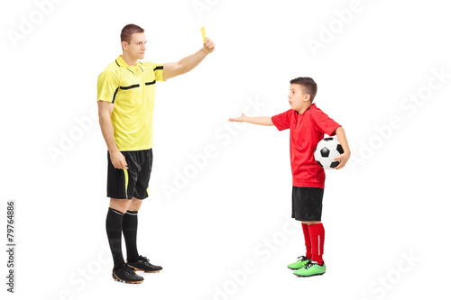 Football referee showing yellow card to a boy