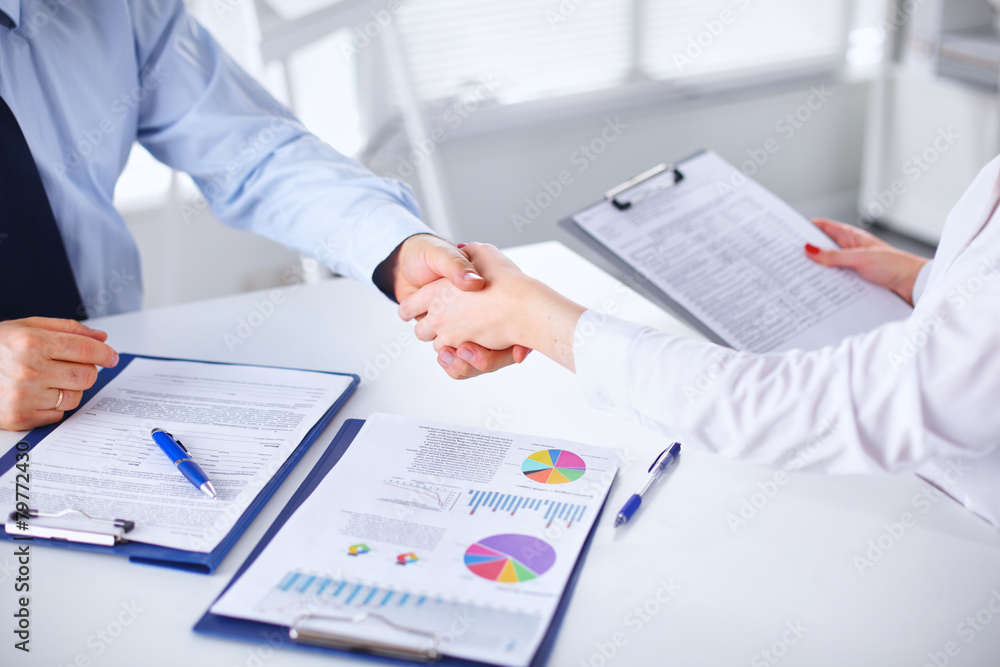 Business people handshake, sitting at the table Business people handshake, sitting at the table