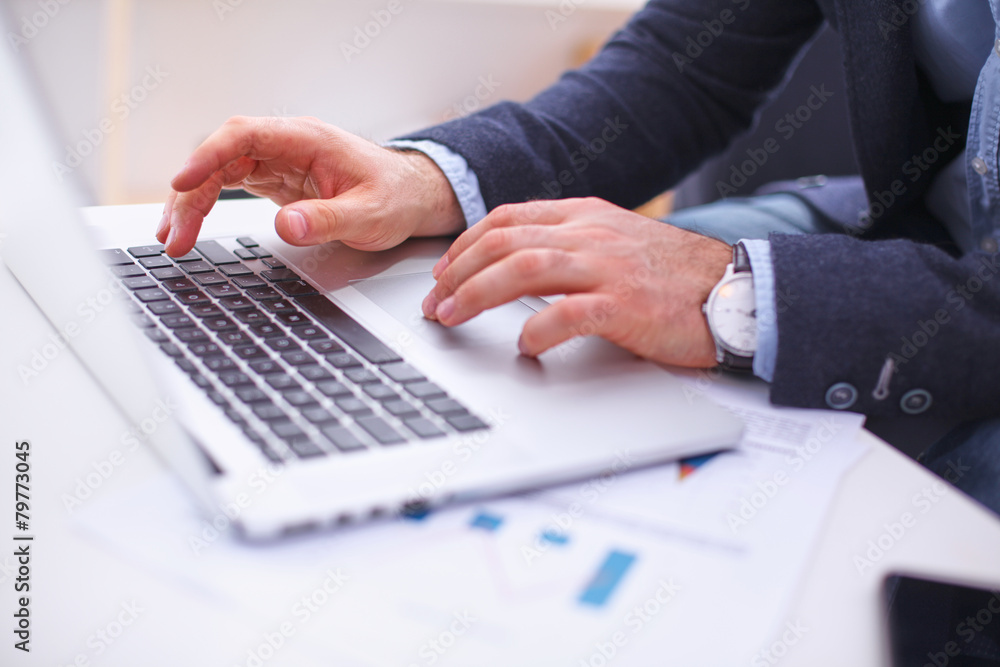 Businessman sitting at table with laptop and documents Businessman sitting at table with laptop and documents