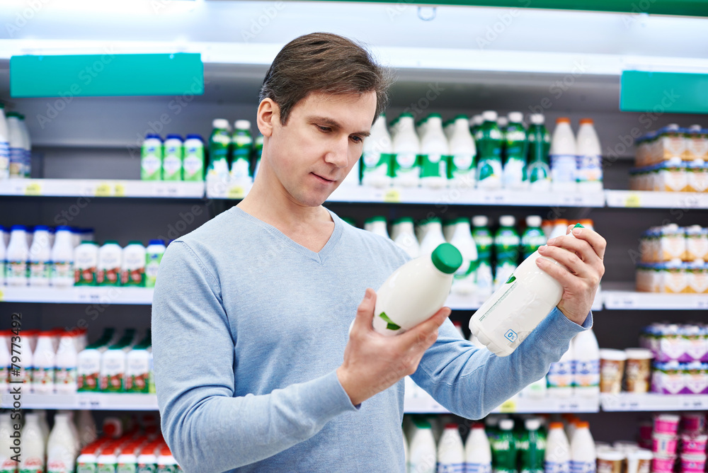 Man chooses dairy products in store Man chooses dairy products in store