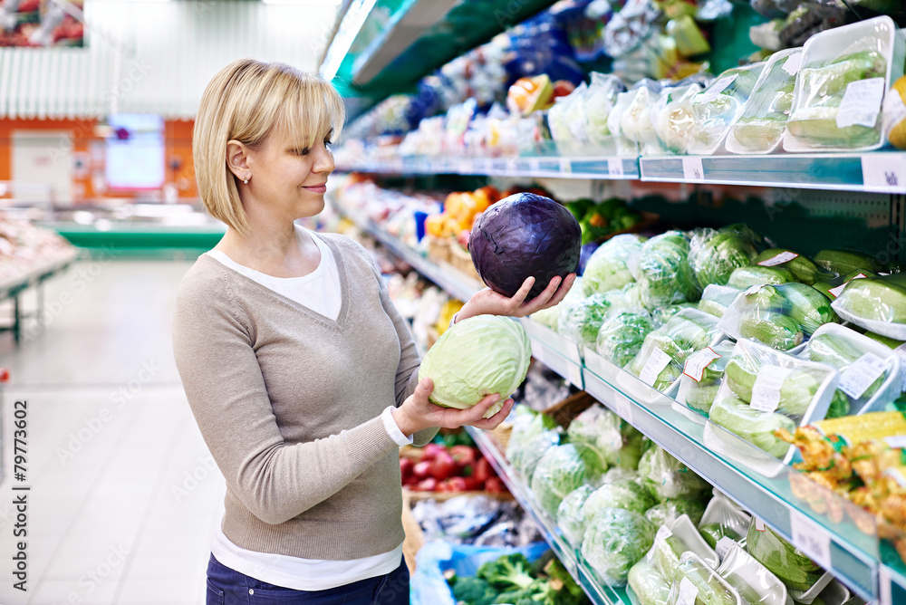Woman buys a red and white cabbage in store