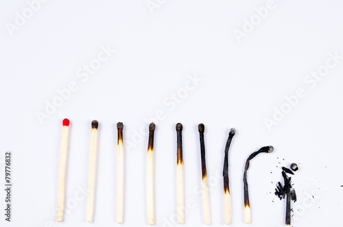 matches in different stages of burning on white
