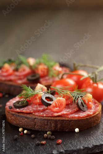 open rye sandwich with salami and vegetables