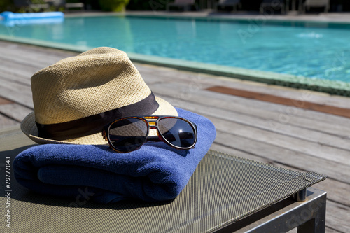 Obraz na plátne sunglasses and white sunhat by the pool