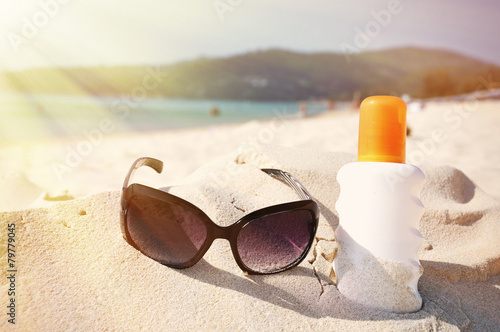 Sunglasses and protection lotion on the beach of Phuket island,