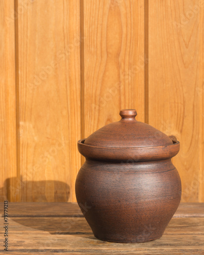 Obraz na plátne Clay pot on wooden boards