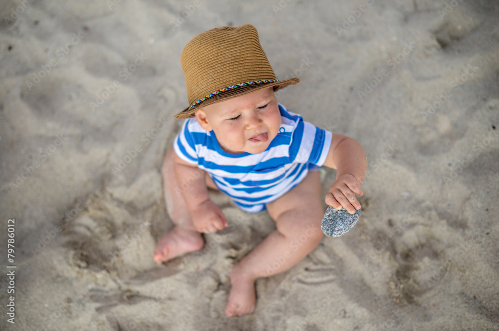 Baby boy with hat sitting on the beach. Baby boy with hat sitting on the beach.