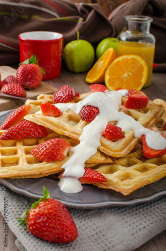 Homemade waffles with maple syrup and strawberries