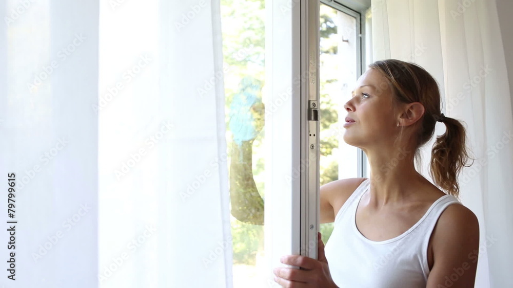 Pretty, young woman doing house works, washing windows Pretty, young woman doing house works, washing windows